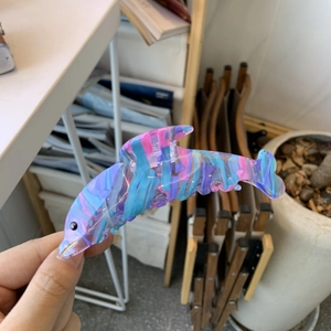 Détail d'une pince à cheveux dauphin en acétate avec un motif de marbre coloré