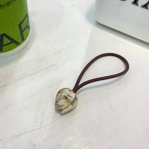 Détail du charm tulipe en résine marbrée sur un élastique à cheveux violet