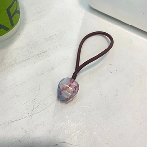 Détail d'un élastique à cheveux violet avec perles en acrylique en forme de tulipe
