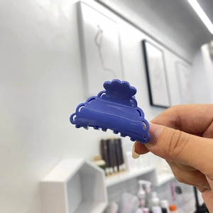 Détail d'une pince à cheveux en acétate bleu foncé avec des motifs ajourés élégants