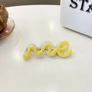 Minimalistische acetaat haarklem met gele me letters design op witte basis