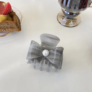 Elegant acetate bow hair claw clip with marble pattern and large pearl accent