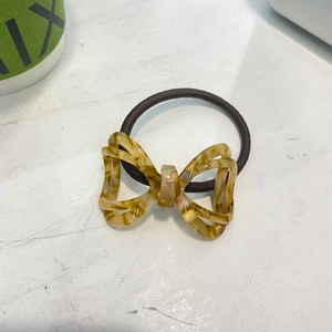 Chic bow hair tie with amber tortoiseshell texture on brown elastic cord for women