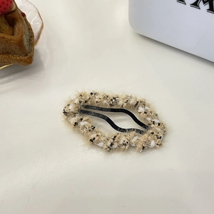 Hohlwolke Haarspange in Creme und Schwarz Tweed Textur auf weißem Tisch Hintergrund