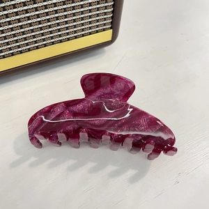 Macro detail of large acetate hair claw clip featuring purple and white marble texture