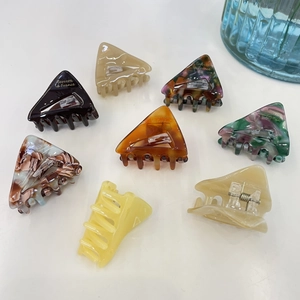 Vue détaillée des pinces à cheveux triangulaires avec motifs écaille et marbre