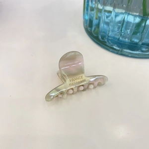 Detailed macro view of acetate hair claw with France Handmade golden logo engraving
