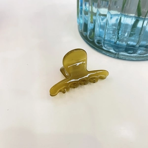 Macro shot of olive green acetate hair clip showing the France Handmade engraving details