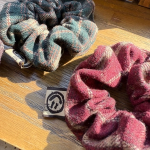 Close-up of thick plaid scrunchies in red and green with a premium wool-like texture