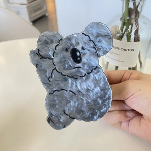 Détail de la pince à cheveux koala en acrylique avec texture marbre gris pour femme