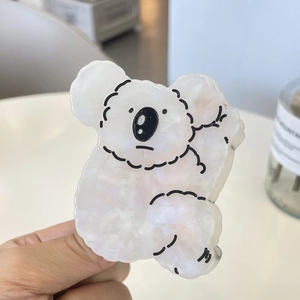 Détail d'une pince à cheveux koala en acétate blanc avec texture effet marbre