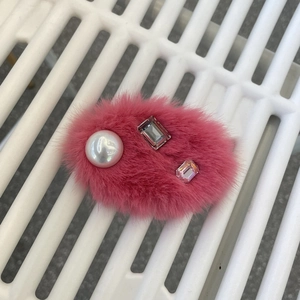 Détail de la pince à cheveux en peluche rose avec perles et cristaux scintillants
