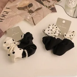 Detail of vintage velvet scrunchie with pearls and polka dots on grey tag card