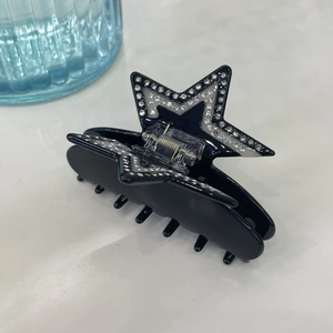 Star-shaped black acetate hair claw clip with sparkling rhinestones and metal spring