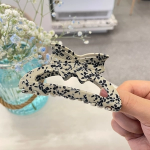 Detail of hollow butterfly hair claw clip with black and white stone pattern marble finish
