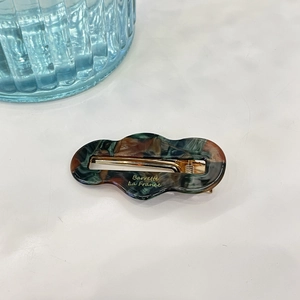 Detail of tortoiseshell hair clip with Barrette La France lettering and gold metal base