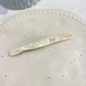 Barrette à cheveux ondulée en acétate blanc crème avec un accent de cristal étincelant