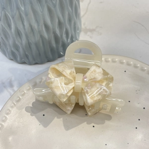 Elegant cream acetate bow hair claw clip with marble texture for a chic look