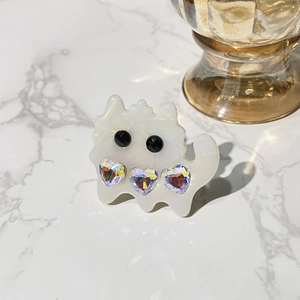 Detail of cute cat-shaped acetate hair clip with rainbow heart crystals and white finish