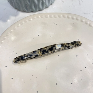 Vue détaillée de la barrette à ressort en acétate avec motif écaille et cristal carré brillant