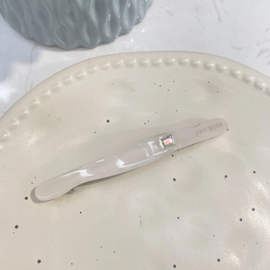 Barrette en acétate élégante avec strass scintillant sur un plateau en céramique
