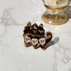 Cute acetate cat hair clip with sparkling rhinestones on a marble background