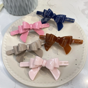 Glossy acetate butterfly bow hair clips in five candy colors with gold logo detail