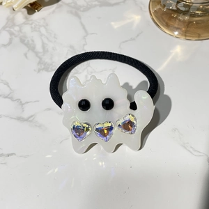 Detail of white acetate cat hair tie featuring sparkling heart-shaped crystals and black gems