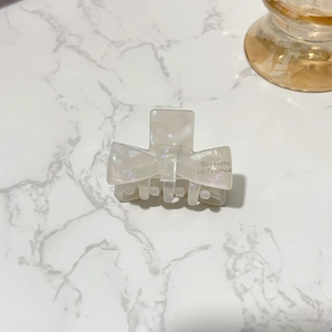Detail of elegant acetate hair claw with cream bow and Barrette la France text