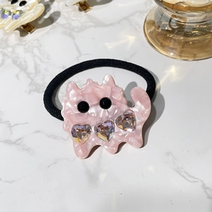 Detail of pink marble acetate cat hair clip with sparkling heart-shaped crystals