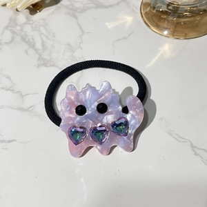 Detail of cute cat-shaped acetic acid hair clip with pink marble texture and crystals