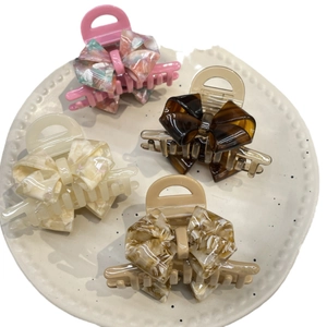 Acetate bow hair claw clips set in marble pattern and brown tortoiseshell finishes