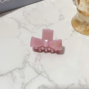 Detail shot of mini pink acetate bow hair claw with gold Barrette La France lettering