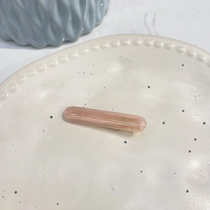 Detailed macro view of the translucent amber pink acetate hair clip with gold engraving