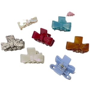 Elegant acetate bow hair claws in multiple colors including blue, red and ivory white