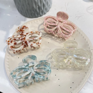 Set of four hollow butterfly hair claws in marble and pearl textures for elegant styling