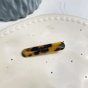 Macro shot of tortoiseshell acetate hair clip with gold France Handmade engraving