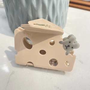 Détail d'une pince à cheveux en forme de fromage avec souris sur marbre poli