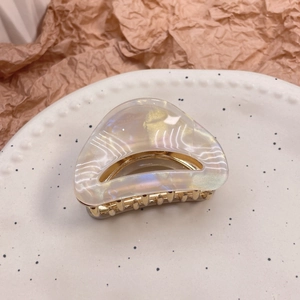 Elegant semi-circular acetate hair claw clip with golden metal base in a pearl finish