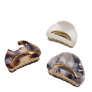 Three-piece acetate half-moon hair claws with gold metal teeth in marble and cream