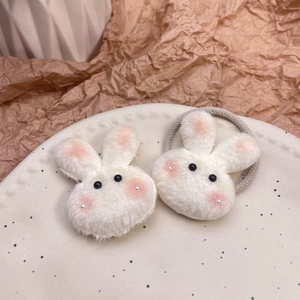 Lindos coleteros de conejo de peluche blanco con orejas rosas en un plato de cerámica