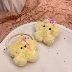 Accesorios para el pelo estrellas de felpa amarilla con lazos y gomas en un plato