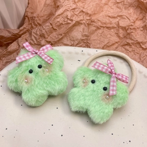 Detalle de pinzas y goma para el pelo de felpa verde claro con forma de estrella suave