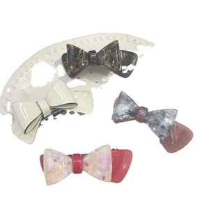 Lot de quatre barrettes à double nœud en acétate coloré aux motifs écaille et marbre