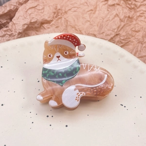Détail de la pince à cheveux chat de Noël sur une assiette en céramique décorative