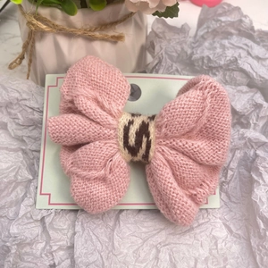 Barrette à cheveux rose tricotée avec nœud et motif léopard sur carte de présentation