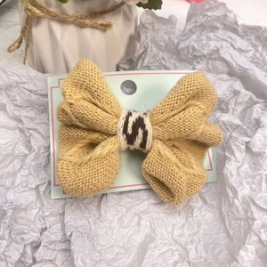Barrette à cheveux avec nœud en laine tricotée jaune pour femmes sur présentoir