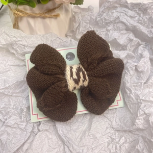 Barrette à cheveux avec nœud en tricot marron et motif jacquard sur cartonnette