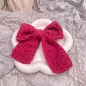 Détail de la pince à cheveux nœud tricotée rose rouge faite main en laine épaisse