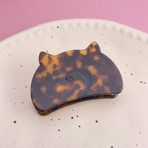 Detailed view of cat-shaped acetate hair claw with classic tortoiseshell pattern finish